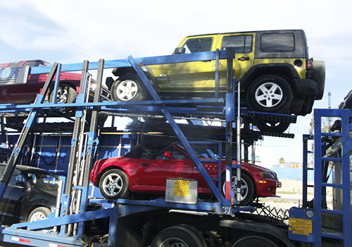 grupo de autos siendo transportados sin rodar por madrina nodriza color azul de forma segura y sin maltratar en tramitadora ayala 
